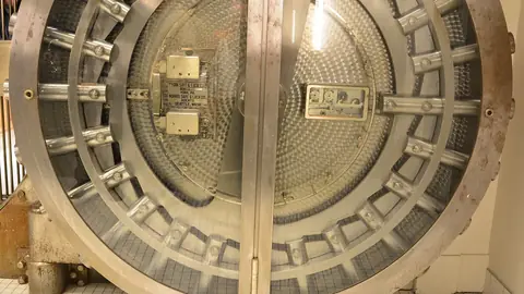 Heavy round steel door of an old bank vault standing open
