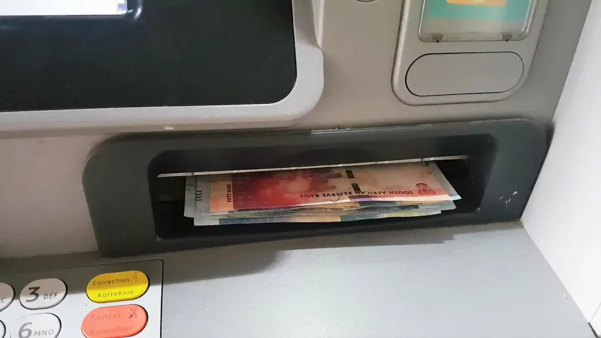 South African R50 and R100 notes coming out of an ATM slot