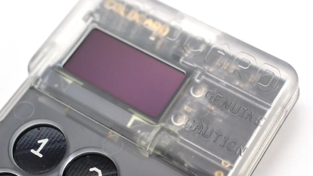 Close-up of a transparent hardware crypto wallet with a small screen