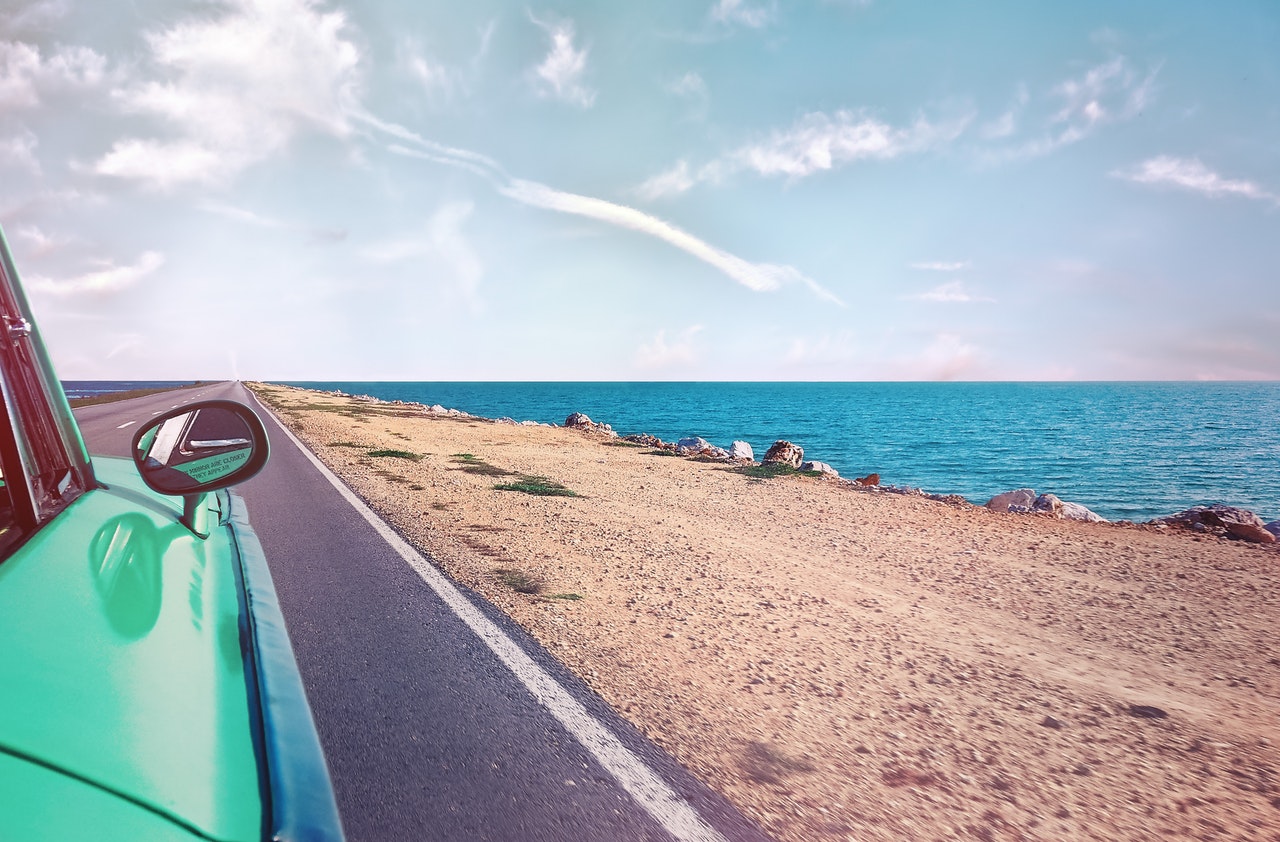 Green car near seashore with blue ocean 1118448